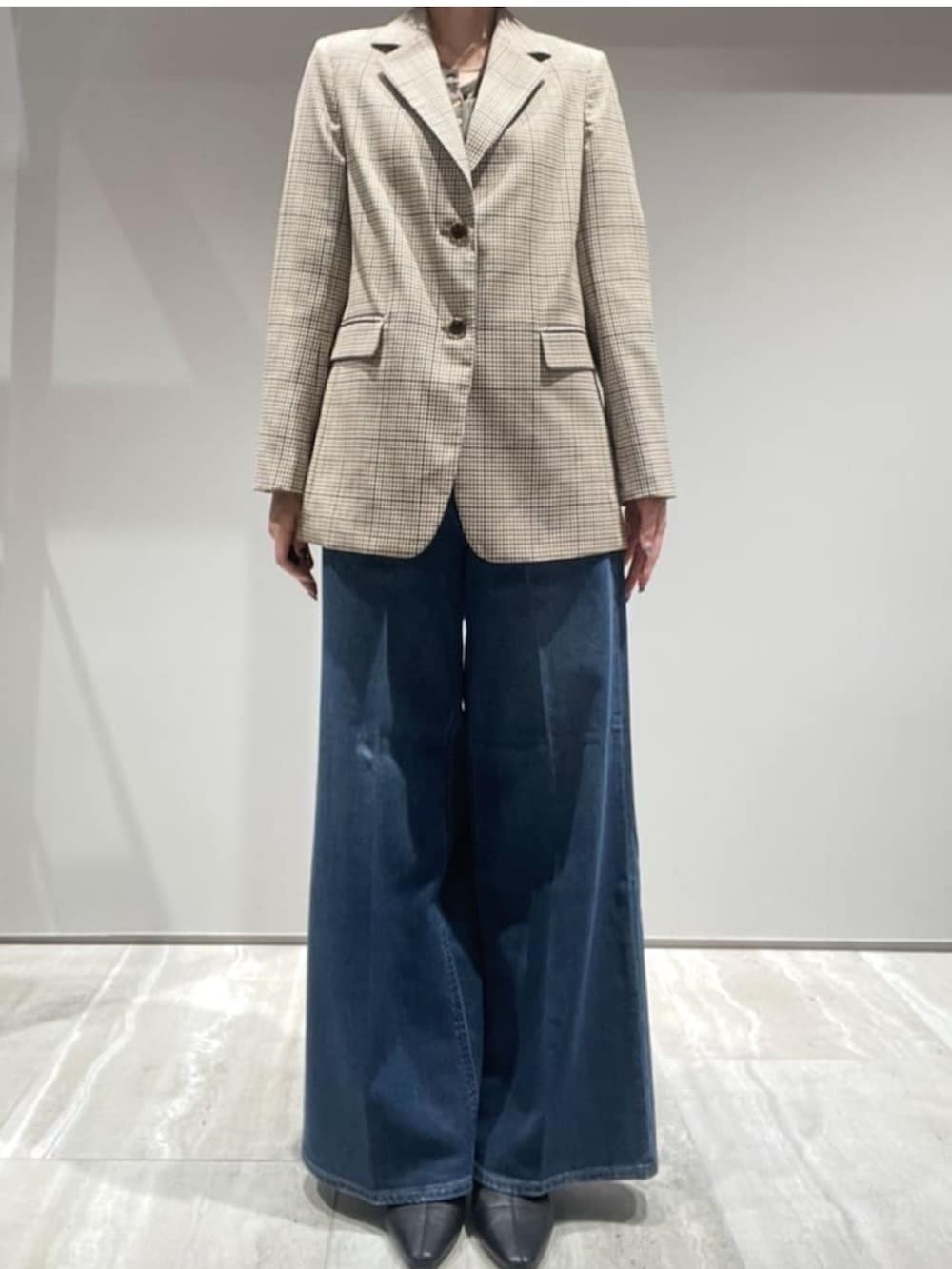 ブラウン系のニット/セーター、ベージュ系のテーラードジャケット、ブラウン系のショルダーバッグを着用したレディースの秋コーディネートの3枚目の写真