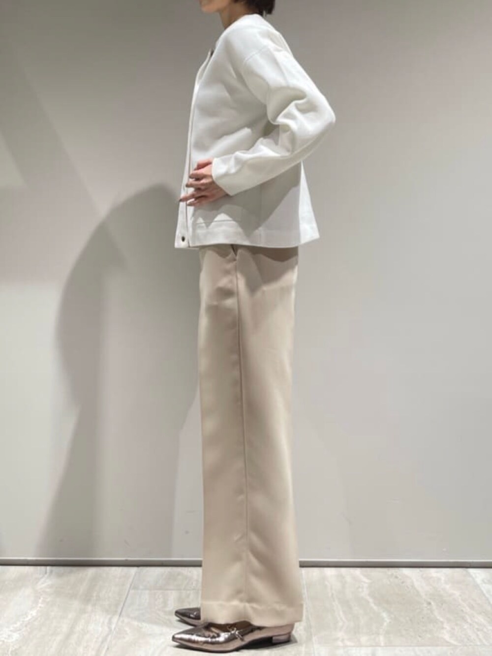 ベージュ系のブルゾン、ホワイト系のカーディガン/ボレロ、ベージュ系のその他パンツを着用したレディースの冬コーディネートの6枚目の写真