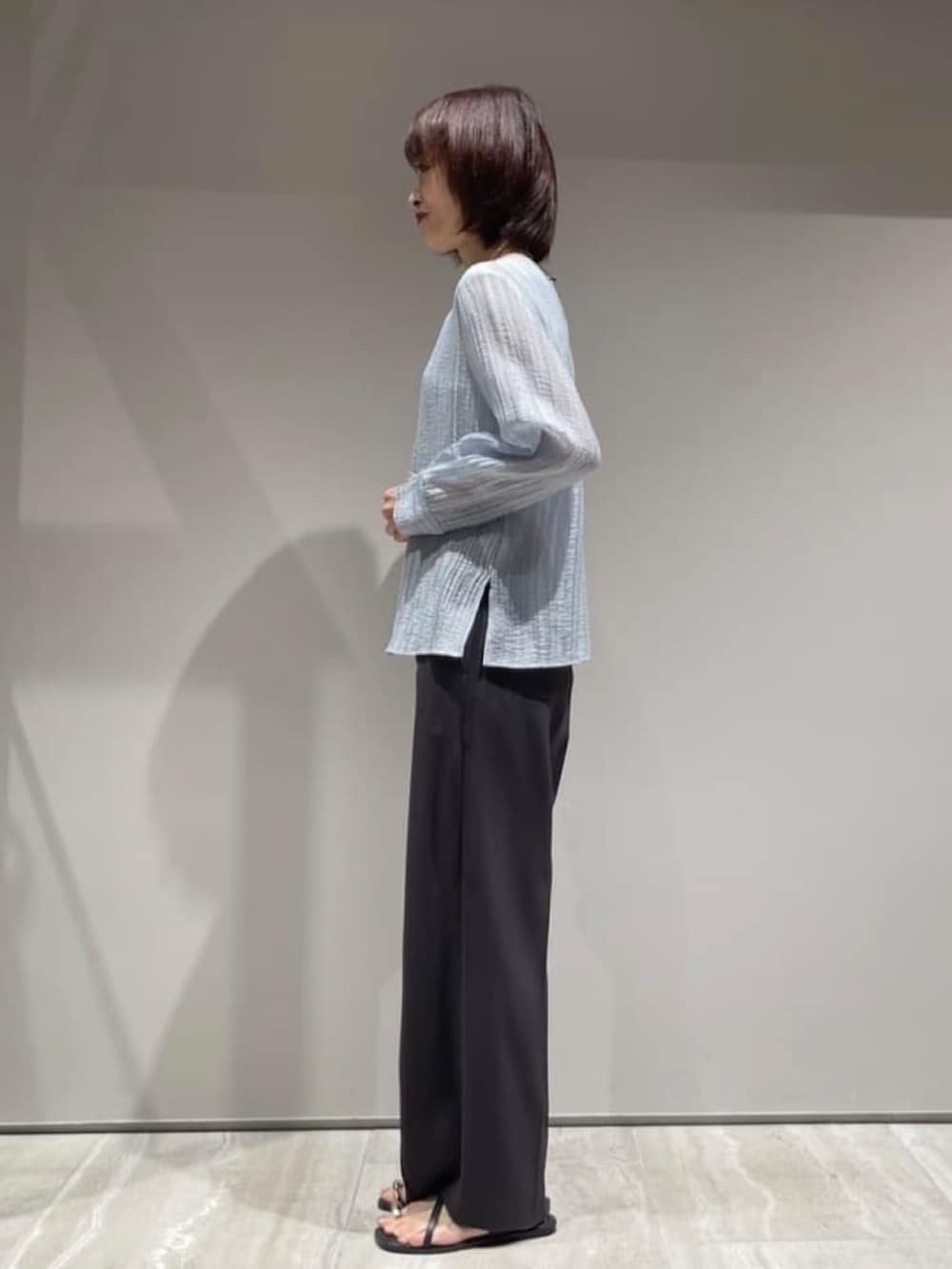 ブルー系のシャツ/ブラウス、グレー系のその他パンツ、シルバー系のネックレスを着用したレディースの春コーディネートの6枚目の写真