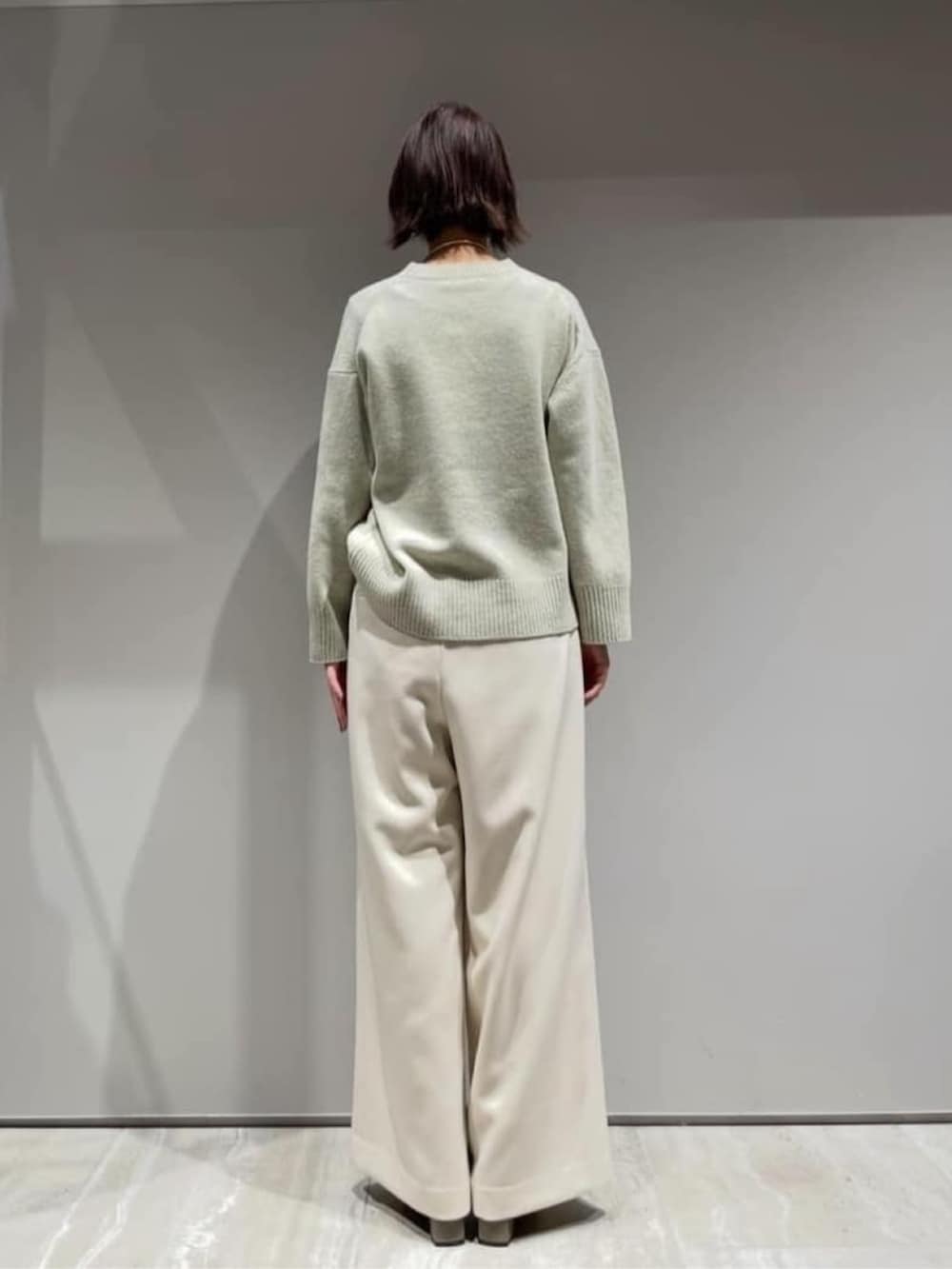 ホワイト系のその他パンツ、グリーン系のニット/セーター、ホワイト系のショルダーバッグを着用したレディースの冬コーディネートの6枚目の写真