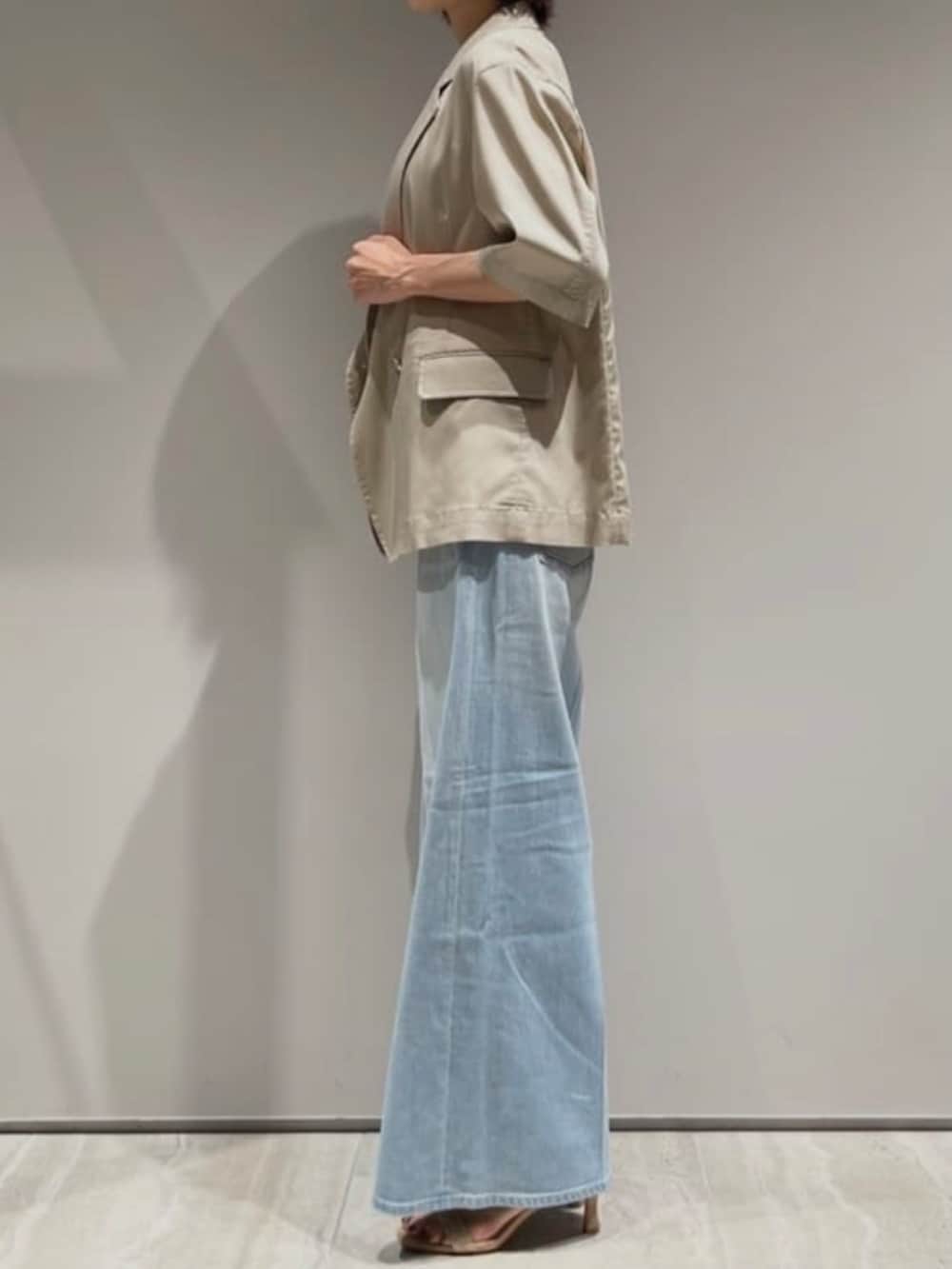 ベージュ系のテーラードジャケット、ホワイト系のTシャツ/カットソー、ブルー系のデニムパンツを着用したレディースの春コーディネートの3枚目の写真
