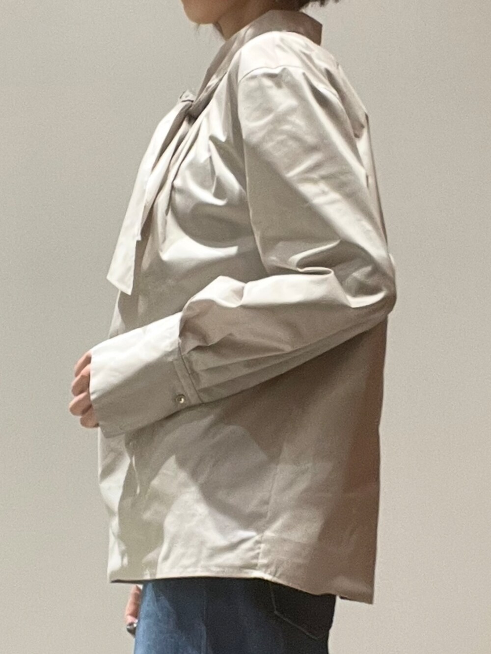 ブルー系のデニムパンツ、ブラウン系のショルダーバッグ、ブラウン系のテーラードジャケットを着用したレディースの秋コーディネートの6枚目の写真