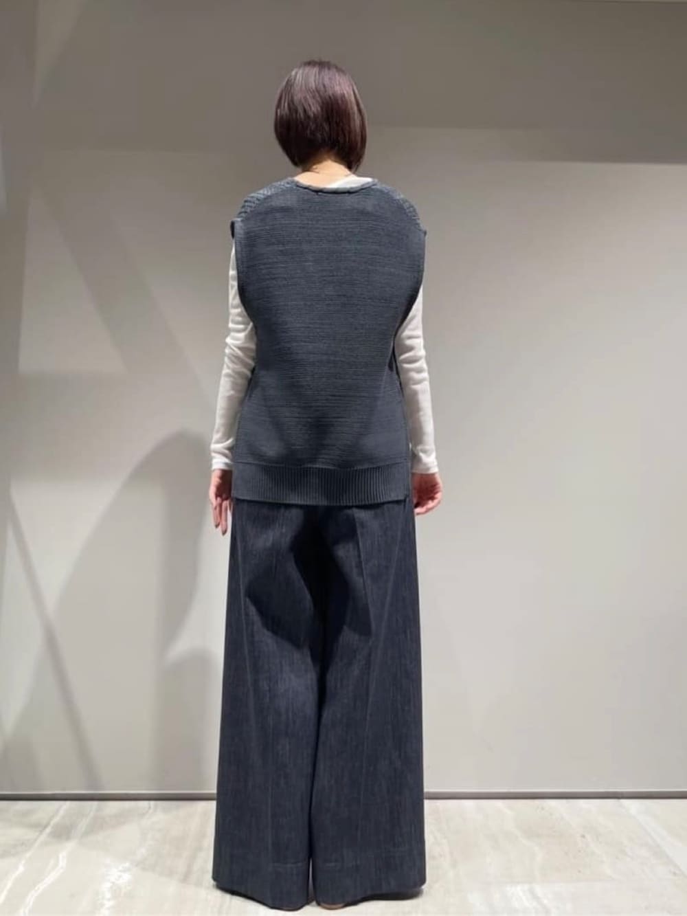 ブルー系のデニムパンツ、ホワイト系のショルダーバッグ、ホワイト系のTシャツ/カットソーを着用したレディースの冬コーディネートの8枚目の写真