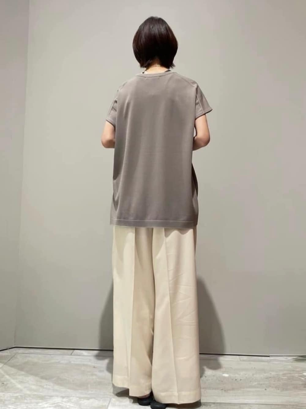 ホワイト系のその他パンツ、グレー系のニット/セーター、ブラック系のショルダーバッグを着用したレディースの春コーディネートの8枚目の写真