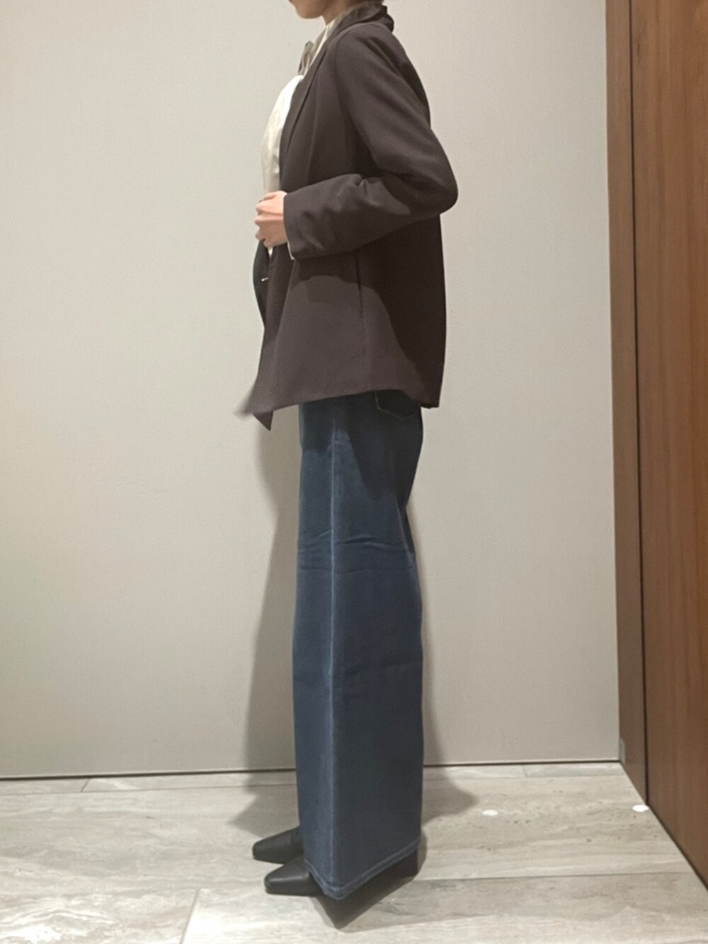 ブルー系のデニムパンツ、ブラウン系のショルダーバッグ、ブラウン系のテーラードジャケットを着用したレディースの秋コーディネートの3枚目の写真