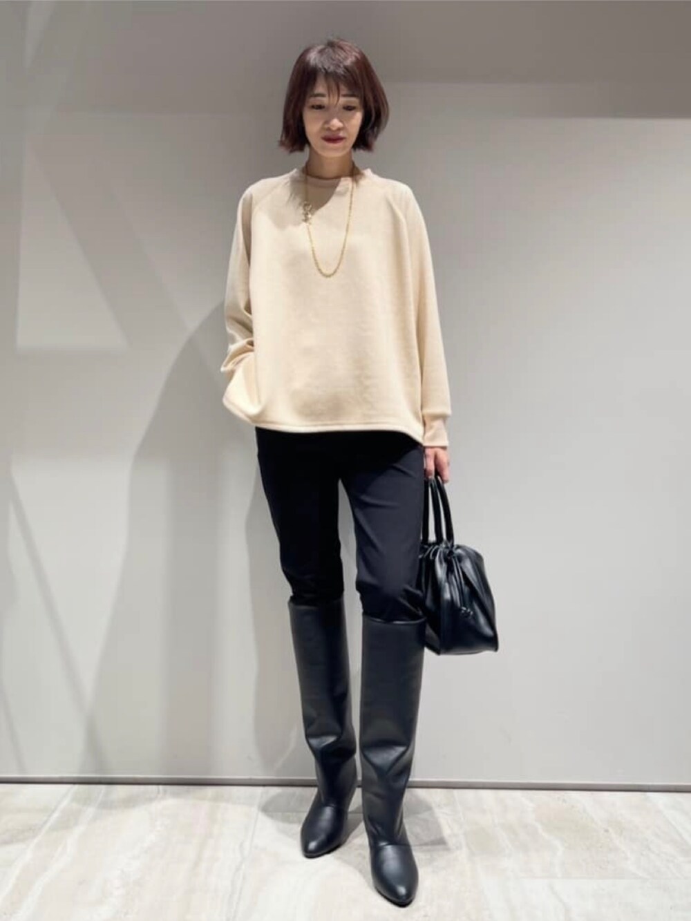 ブラック系のその他パンツ、ブラック系のダウンジャケット/コート、ベージュ系のスウェットを着用したレディースの冬コーディネートの6枚目の写真