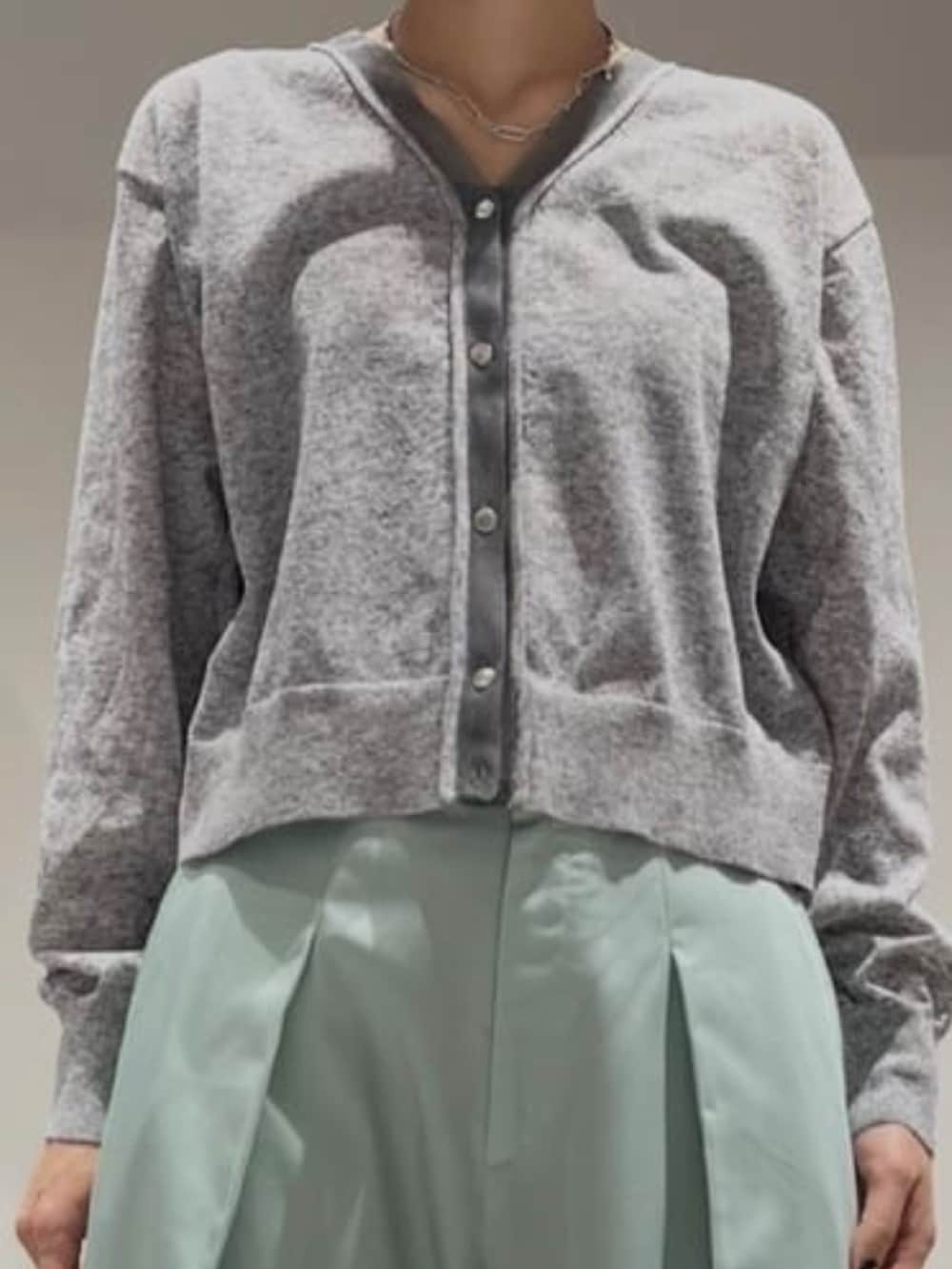 グリーン系のその他パンツ、グレー系のカーディガン/ボレロ、シルバー系のネックレスを着用したレディースの冬コーディネートの3枚目の写真