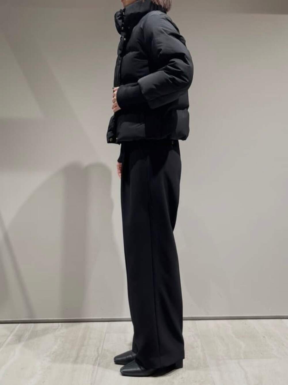 ブラック系のその他パンツ、ブラック系のダウンジャケット/コート、グレー系のニット/セーターを着用したレディースの冬コーディネートの5枚目の写真