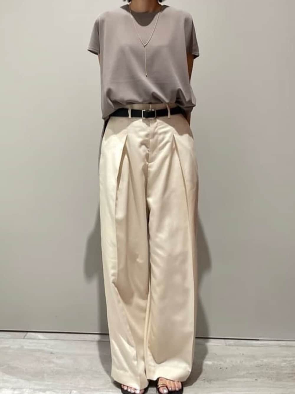 ホワイト系のその他パンツ、グレー系のニット/セーター、ブラック系のショルダーバッグを着用したレディースの春コーディネートの3枚目の写真