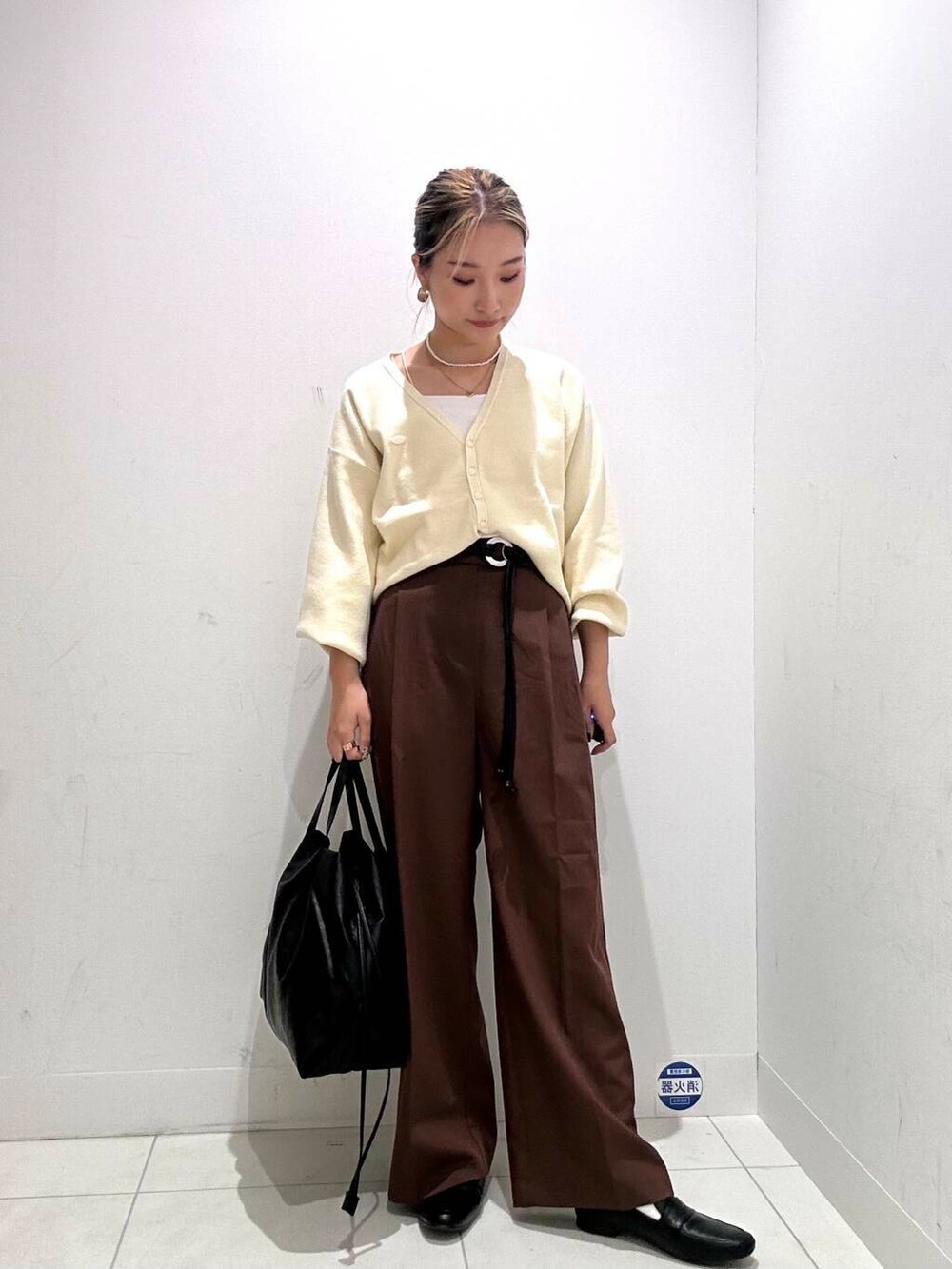 ブラック系のトートバッグ、ブラウン系のその他パンツ、ホワイト系のカーディガン/ボレロを着用したレディースの秋コーディネートの2枚目の写真