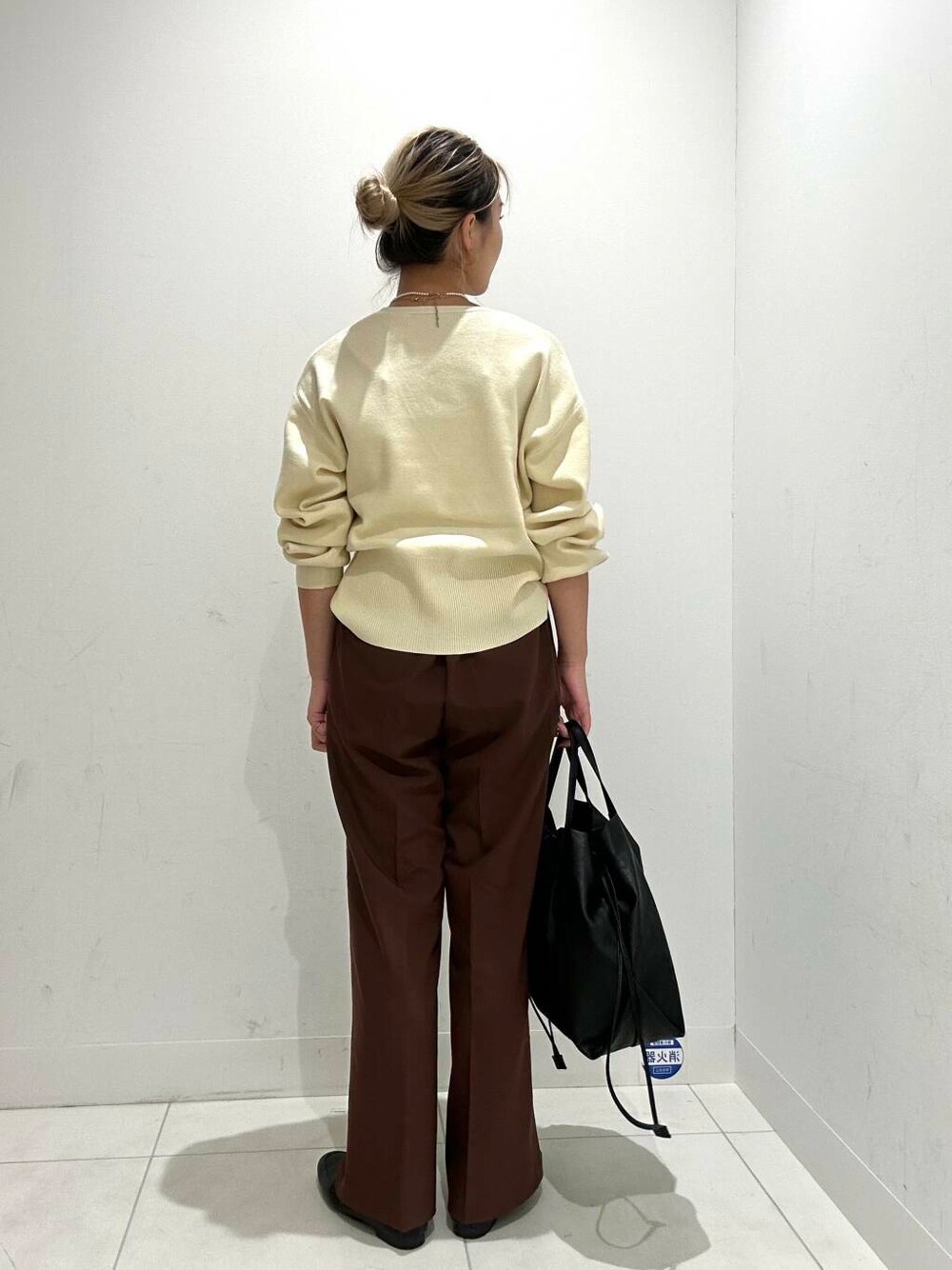 ブラック系のトートバッグ、ブラウン系のその他パンツ、ホワイト系のカーディガン/ボレロを着用したレディースの秋コーディネートの3枚目の写真