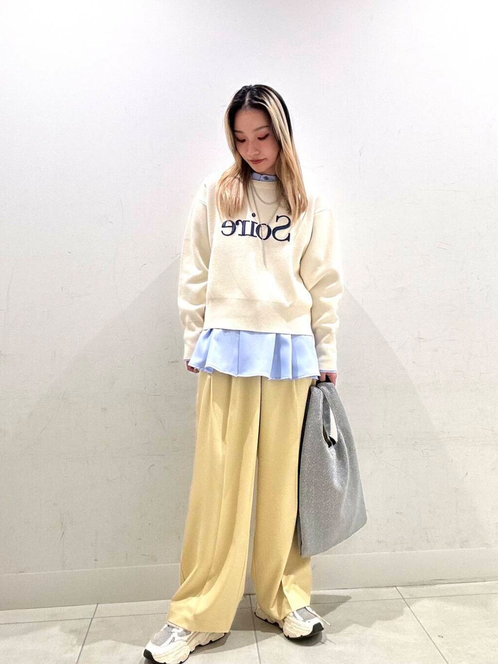 シルバー系のトートバッグ、ホワイト系のニット/セーター、イエロー系のその他パンツを着用したレディースの冬コーディネートの2枚目の写真