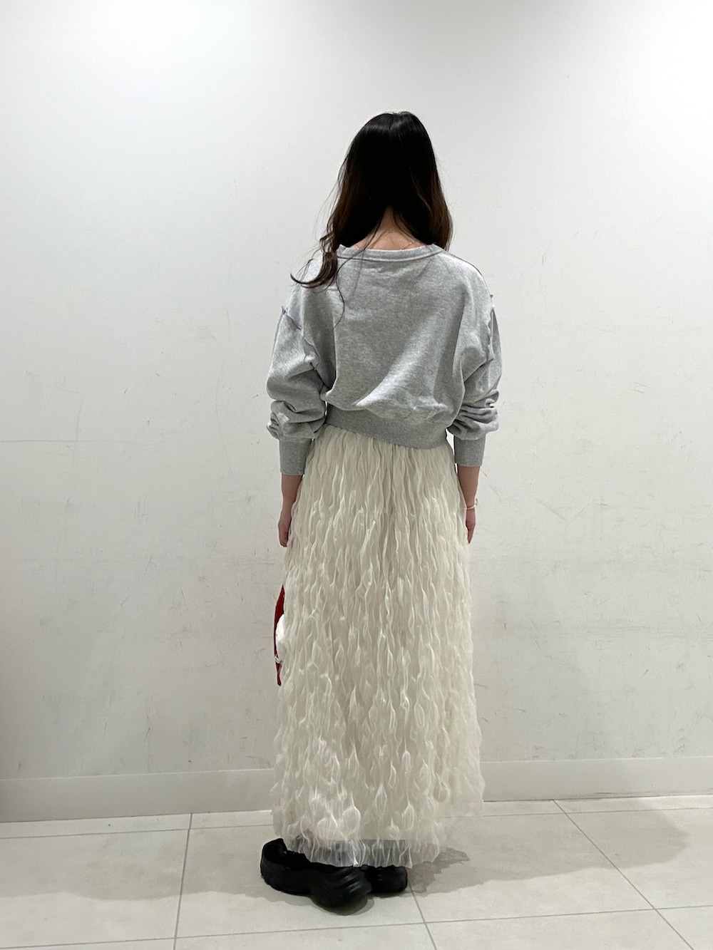 ホワイト系のスカート、レッド系のエコバッグ/サブバッグ、グレー系のスウェットを着用したレディースの春コーディネートの3枚目の写真