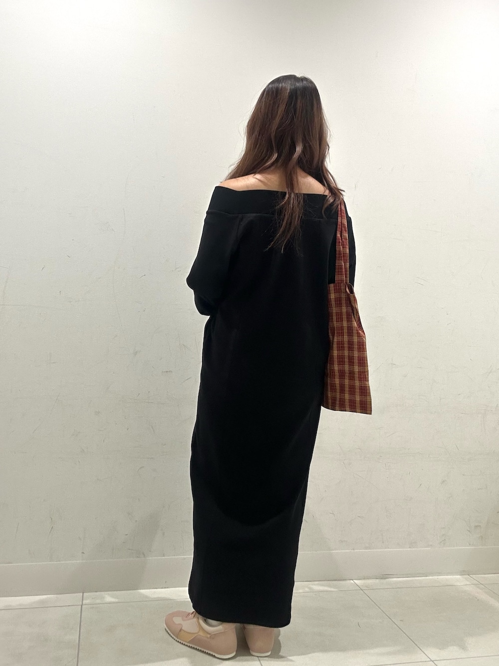 ブラック系のワンピース、レッド系のトートバッグ、ピンク系のスニーカーを着用したレディースの秋コーディネートの3枚目の写真