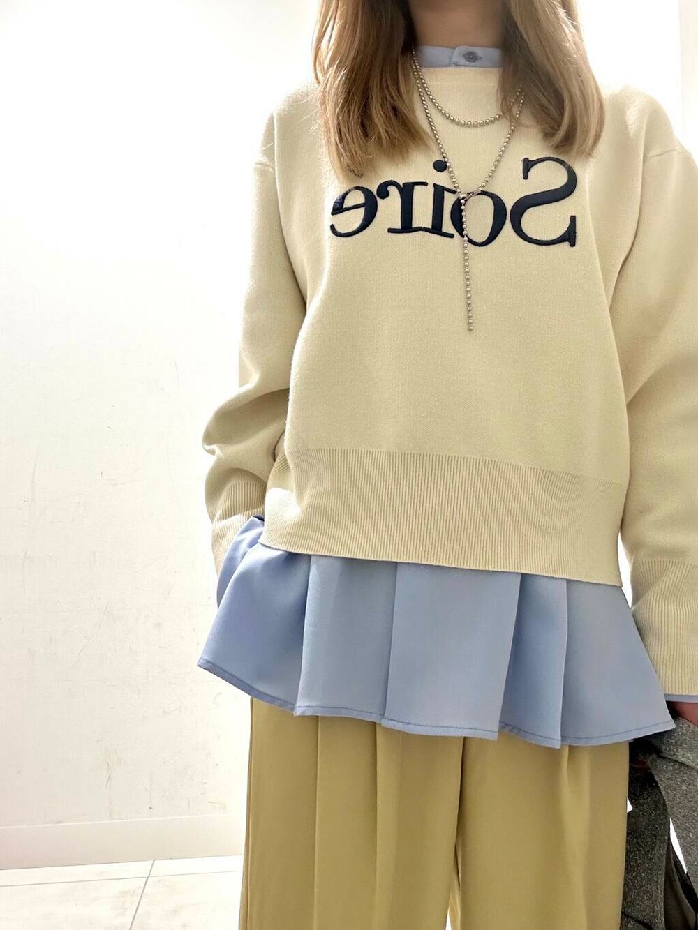 シルバー系のトートバッグ、ホワイト系のニット/セーター、イエロー系のその他パンツを着用したレディースの冬コーディネートの3枚目の写真