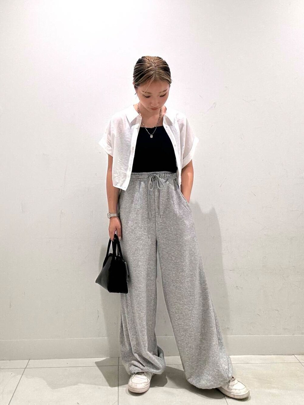 ブラック系のショルダーバッグ、ホワイト系のシャツ/ブラウス、ブルー系のキャミソールを着用したレディースの夏コーディネートの2枚目の写真