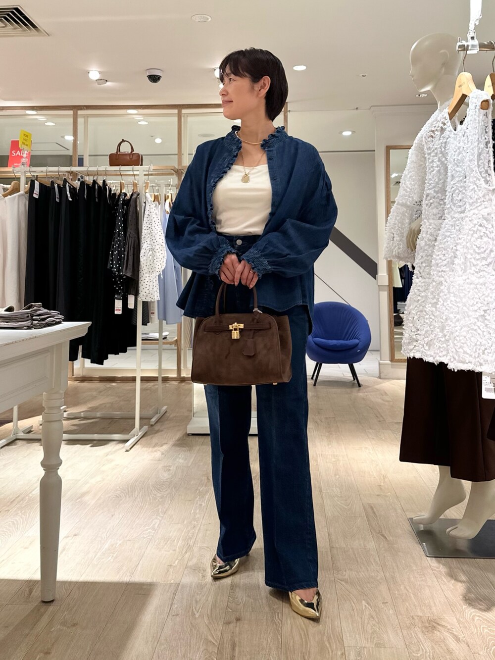 ブラウン系のトートバッグ、ブルー系のデニムパンツ、ブルー系のシャツ/ブラウスを着用したレディースの夏コーディネートの6枚目の写真