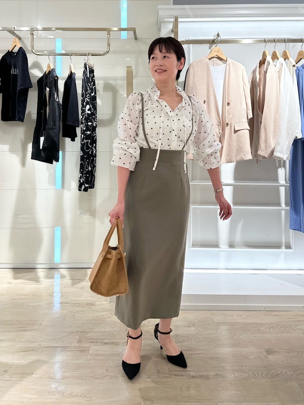 グリーン系のスカート、イエロー系のトートバッグ、ホワイト系のシャツ/ブラウスを着用したレディースの夏コーディネートの6枚目の写真