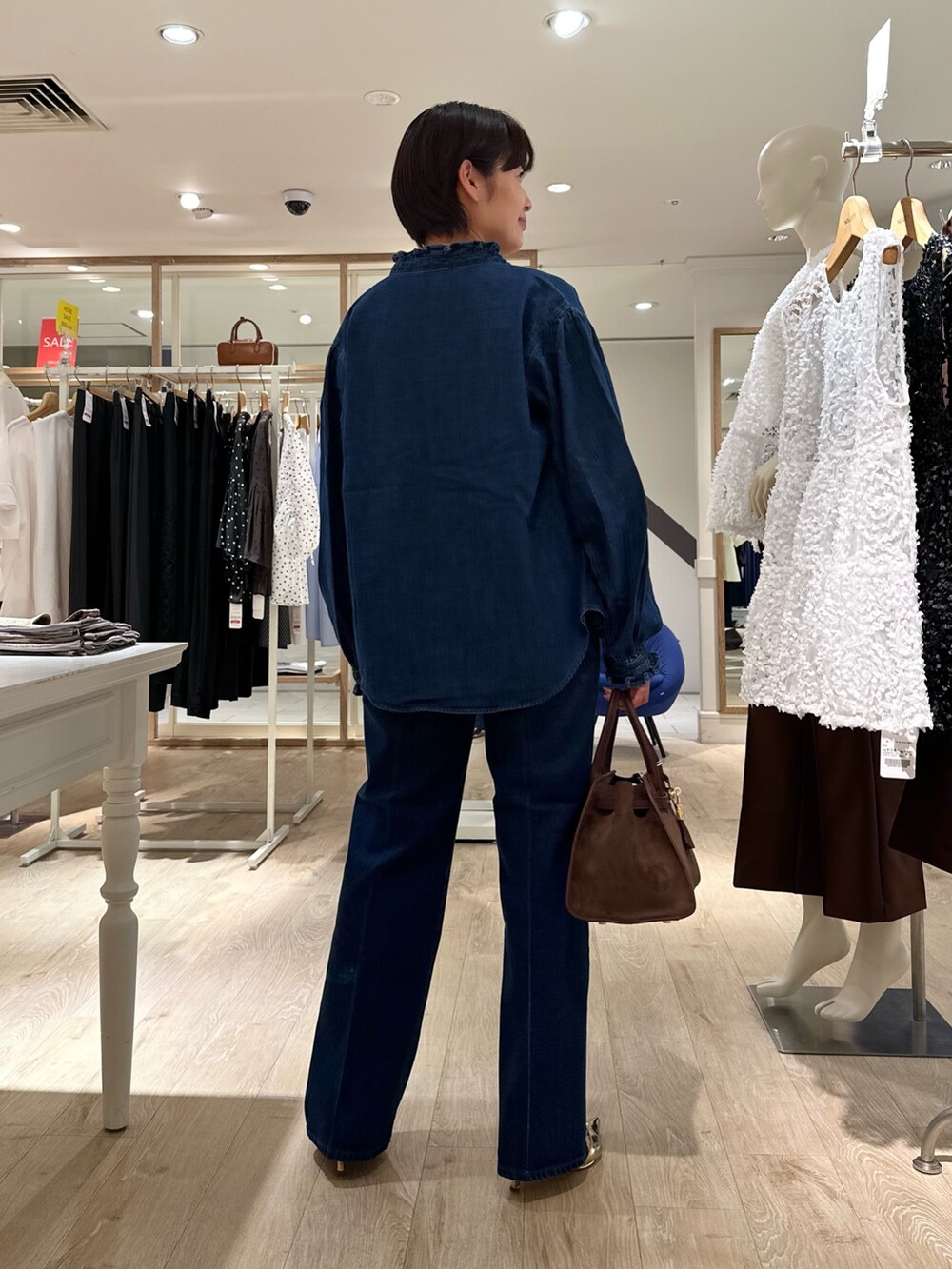 ブラウン系のトートバッグ、ブルー系のデニムパンツ、ブルー系のシャツ/ブラウスを着用したレディースの夏コーディネートの5枚目の写真