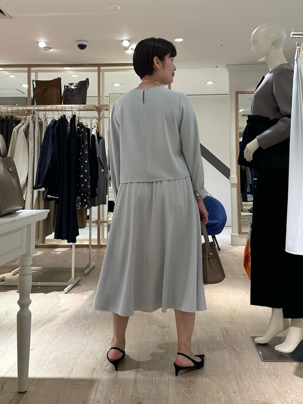 ベージュ系のショルダーバッグ、ブルー系のスカート、ブルー系のシャツ/ブラウスを着用したレディースの秋コーディネートの3枚目の写真