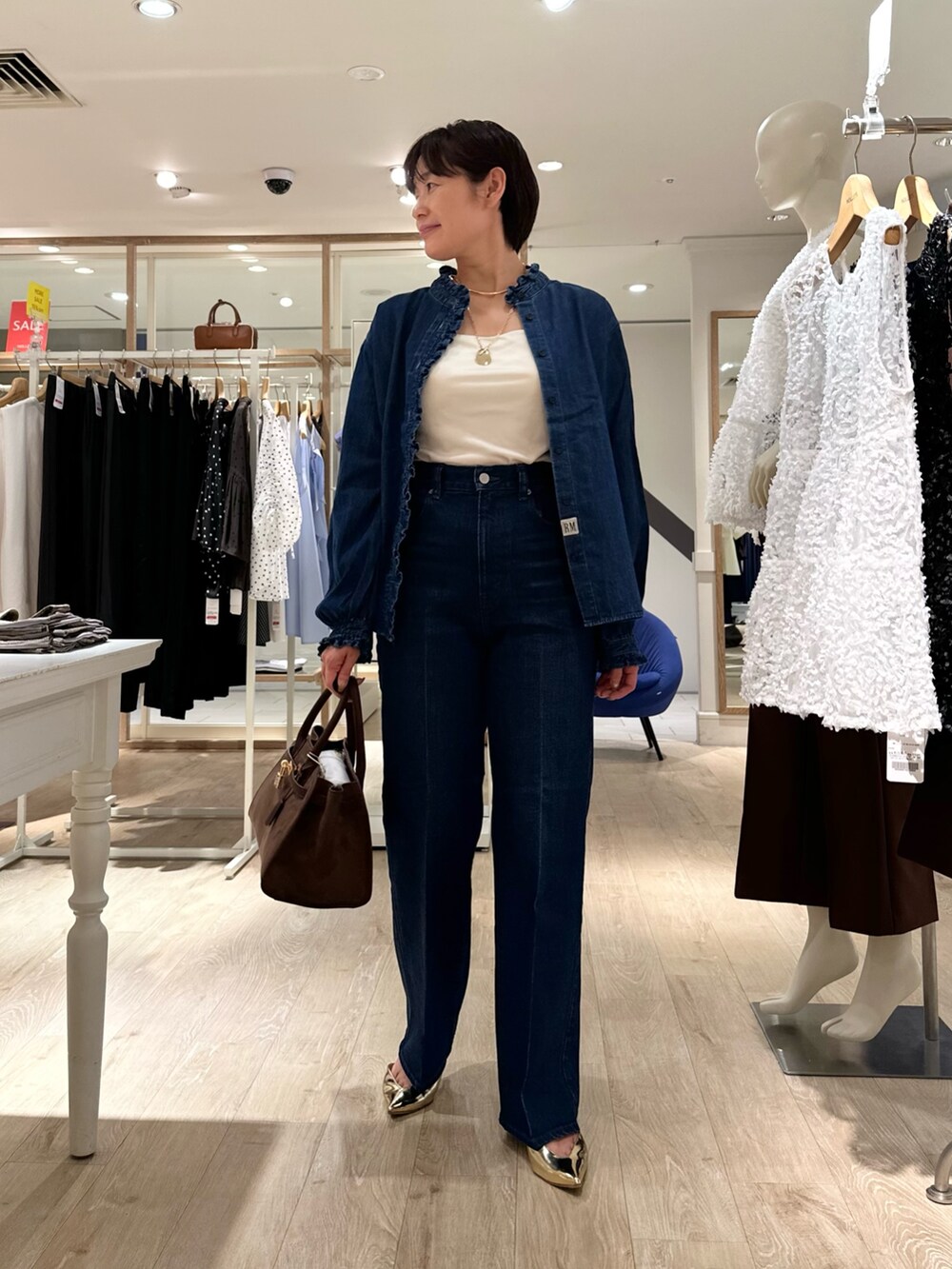 ブラウン系のトートバッグ、ブルー系のデニムパンツ、ブルー系のシャツ/ブラウスを着用したレディースの夏コーディネートの7枚目の写真