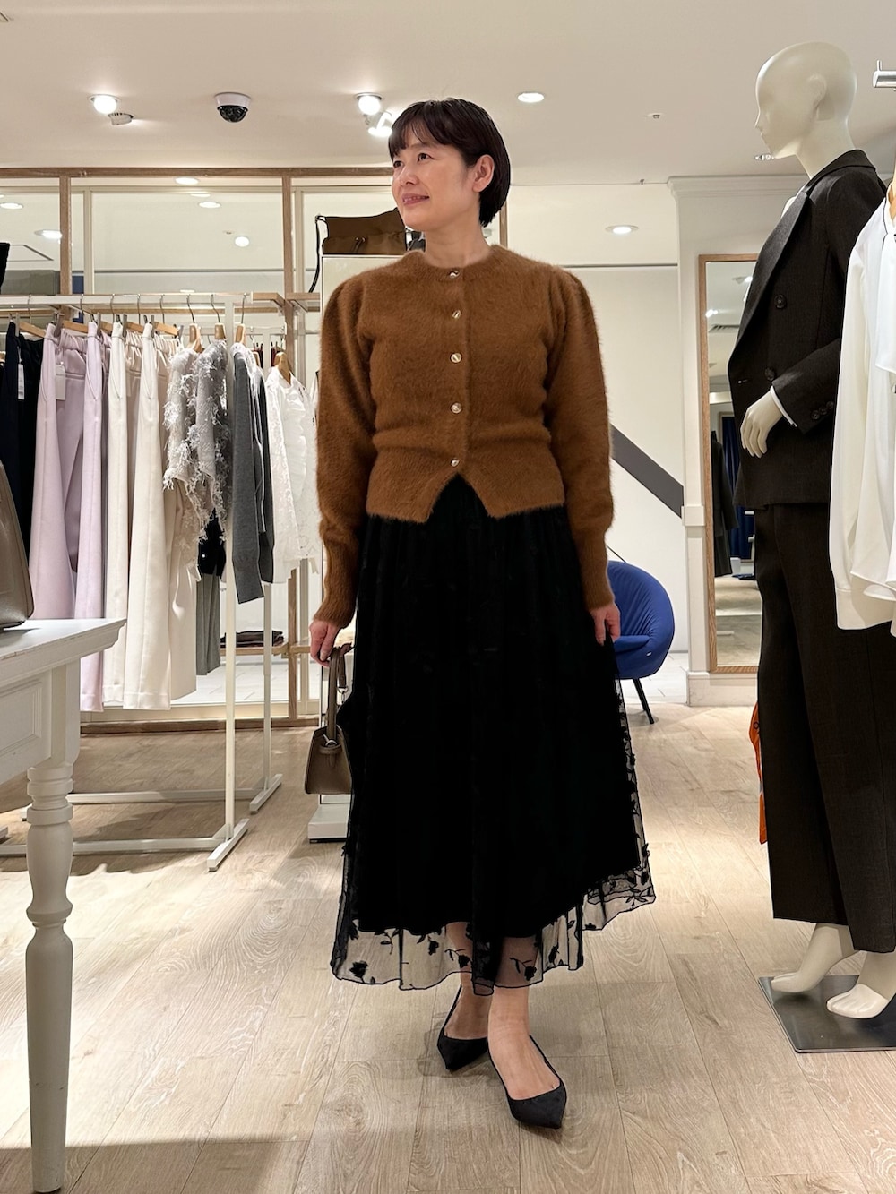 ブラウン系のカーディガン/ボレロ、ブラック系のスカート、ベージュ系のショルダーバッグを着用したレディースの秋コーディネートの8枚目の写真