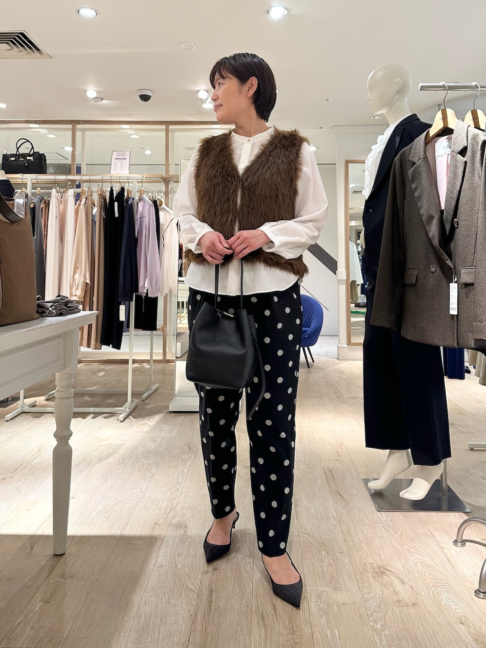 ブラック系のその他パンツ、ブラック系のショルダーバッグ、ホワイト系のシャツ/ブラウスを着用したレディースの秋コーディネートの3枚目の写真