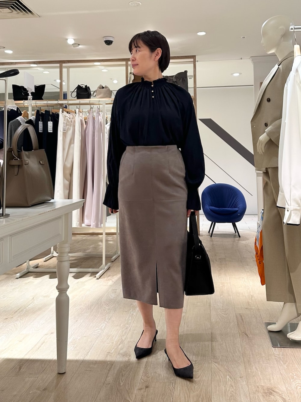 ブルー系のシャツ/ブラウス、グリーン系のスカート、ブラック系のショルダーバッグを着用したレディースの秋コーディネートの7枚目の写真