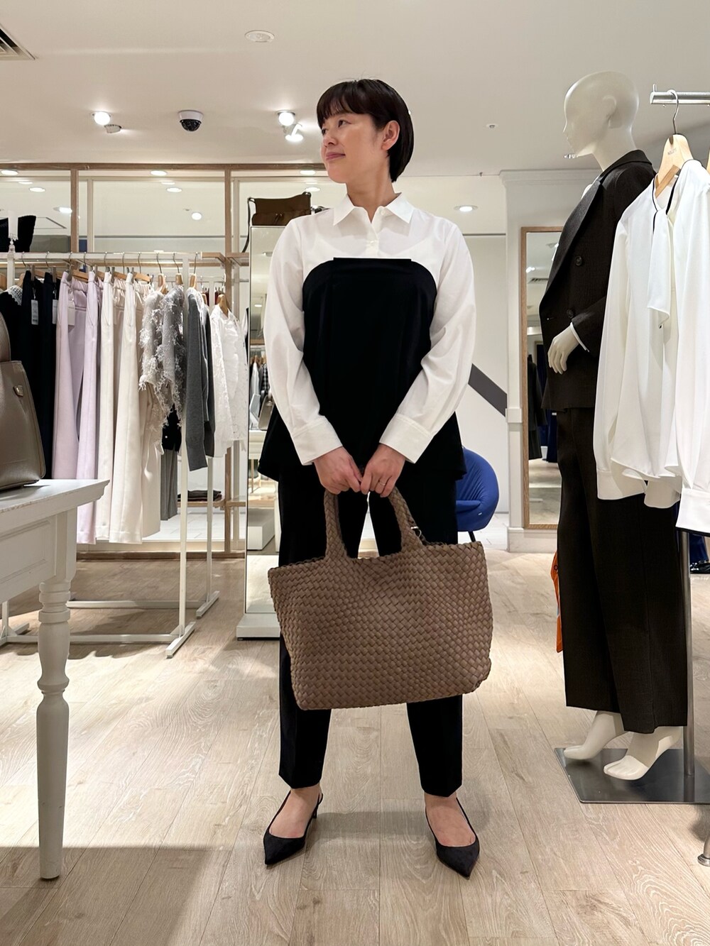 ブラック系のその他パンツ、ベージュ系のトートバッグ、ホワイト系のシャツ/ブラウスを着用したレディースの秋コーディネートの2枚目の写真