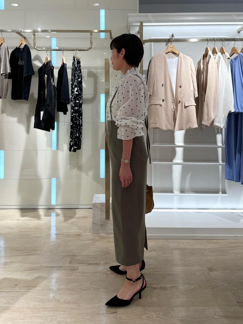 グリーン系のスカート、イエロー系のトートバッグ、ホワイト系のシャツ/ブラウスを着用したレディースの夏コーディネートの4枚目の写真