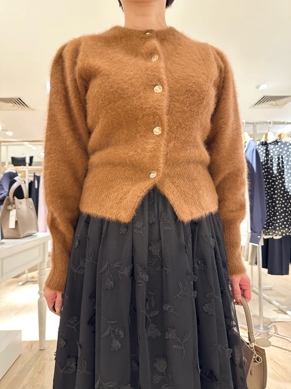 ブラウン系のカーディガン/ボレロ、ブラック系のスカート、ベージュ系のショルダーバッグを着用したレディースの秋コーディネートの9枚目の写真