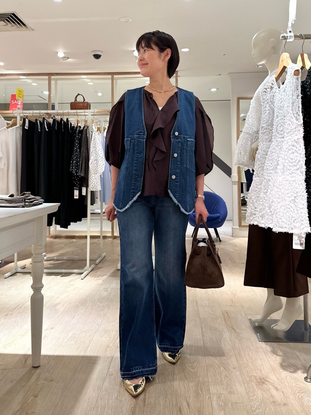 ブラウン系のシャツ/ブラウス、ブルー系のベスト、ブラウン系のトートバッグを着用したレディースの夏コーディネートの8枚目の写真