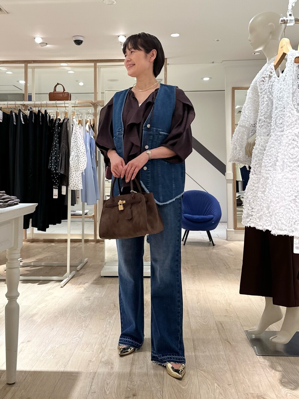 ブラウン系のシャツ/ブラウス、ブルー系のベスト、ブラウン系のトートバッグを着用したレディースの夏コーディネートの7枚目の写真