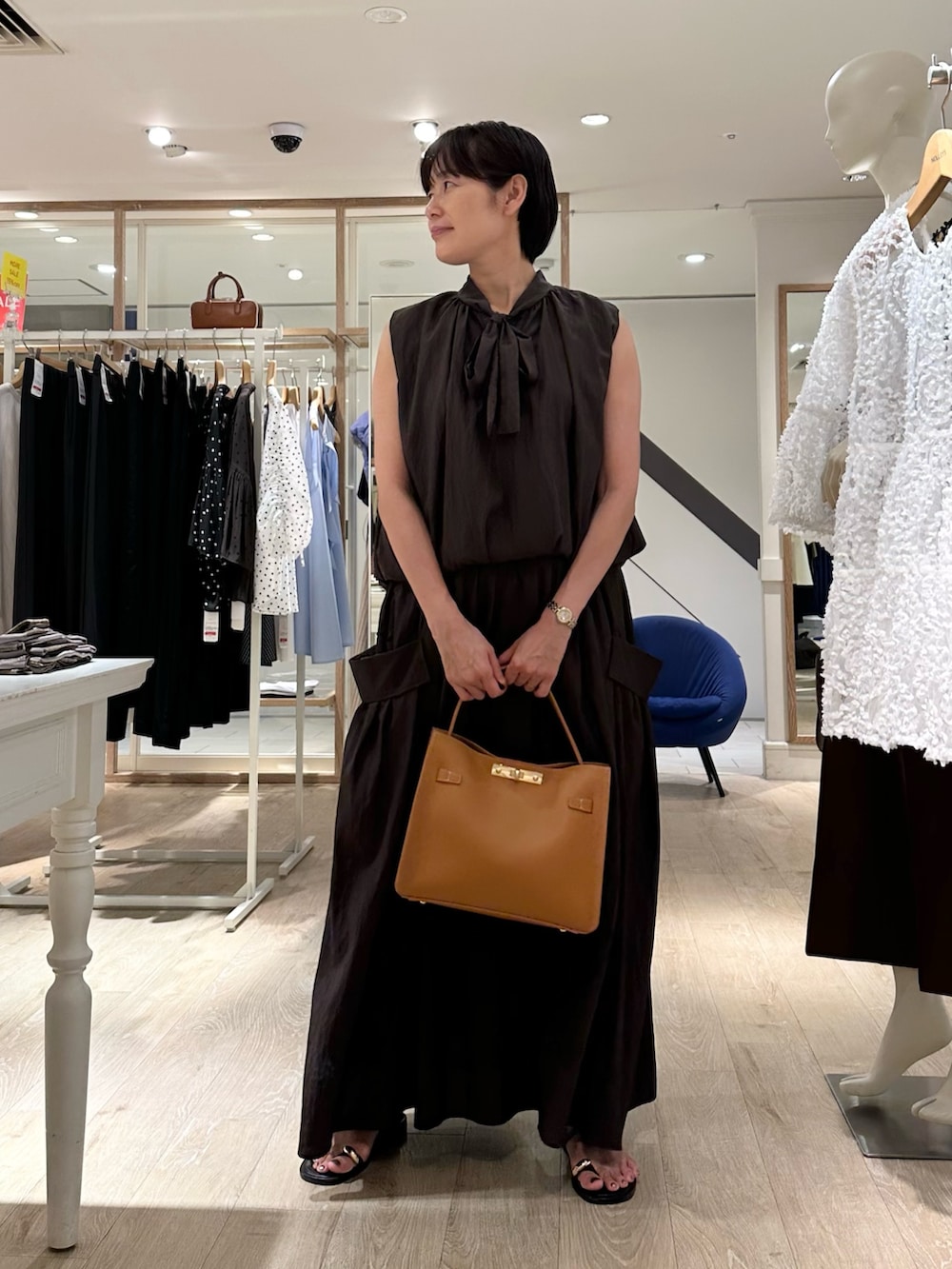 ブラウン系のシャツ/ブラウス、ブラウン系のスカート、イエロー系のショルダーバッグを着用したレディースの夏コーディネートの5枚目の写真