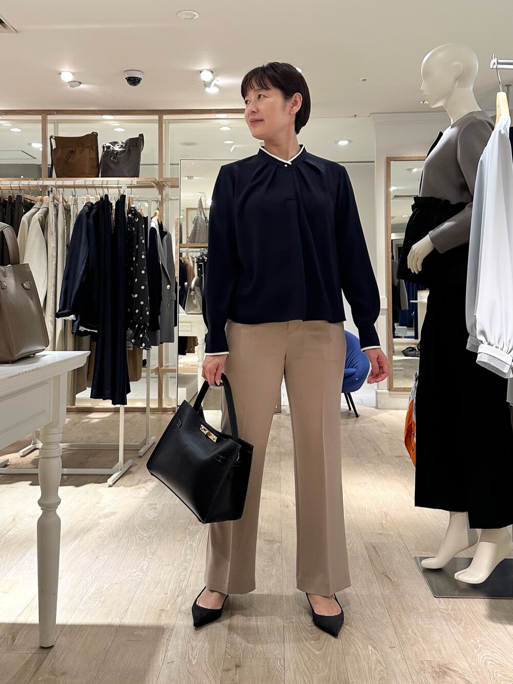 ベージュ系のその他パンツ、ブラック系のショルダーバッグ、ブルー系のシャツ/ブラウスを着用したレディースの秋コーディネートの9枚目の写真