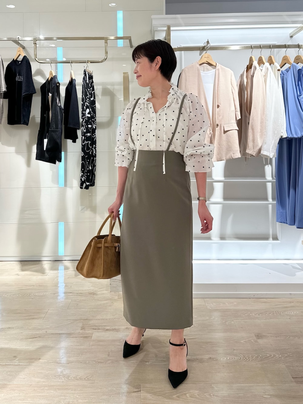 グリーン系のスカート、イエロー系のトートバッグ、ホワイト系のシャツ/ブラウスを着用したレディースの夏コーディネートの2枚目の写真