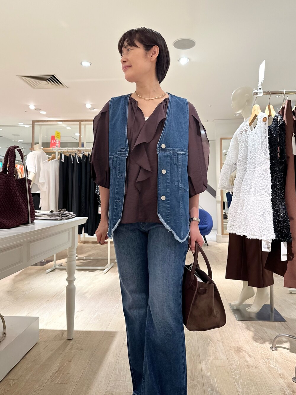 ブラウン系のシャツ/ブラウス、ブルー系のベスト、ブラウン系のトートバッグを着用したレディースの夏コーディネートの9枚目の写真