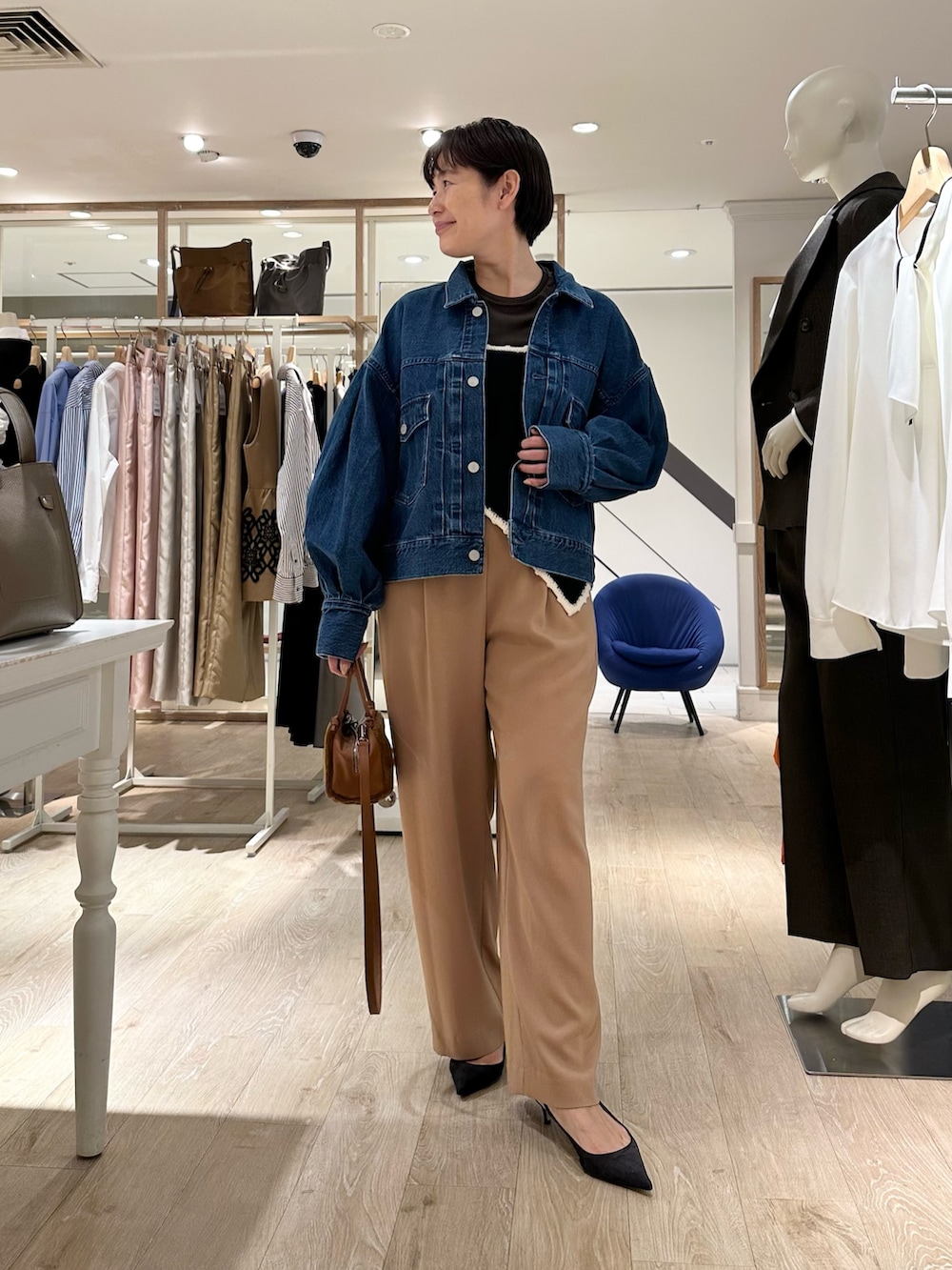 ブラック系のニット/セーター、イエロー系のショルダーバッグ、イエロー系のその他パンツを着用したレディースの秋コーディネートの5枚目の写真