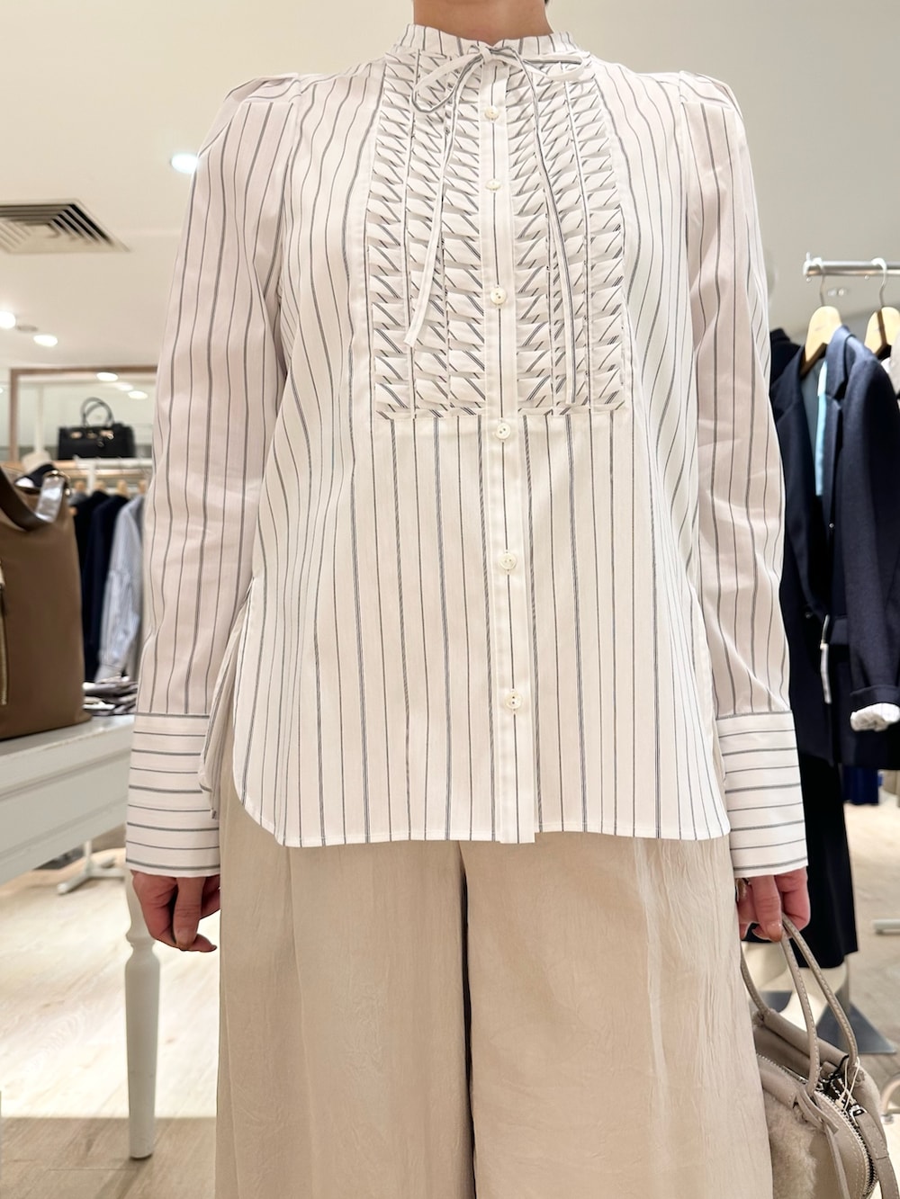 ホワイト系のシャツ/ブラウス、ベージュ系のショルダーバッグ、ベージュ系のその他パンツを着用したレディースの秋コーディネートの9枚目の写真