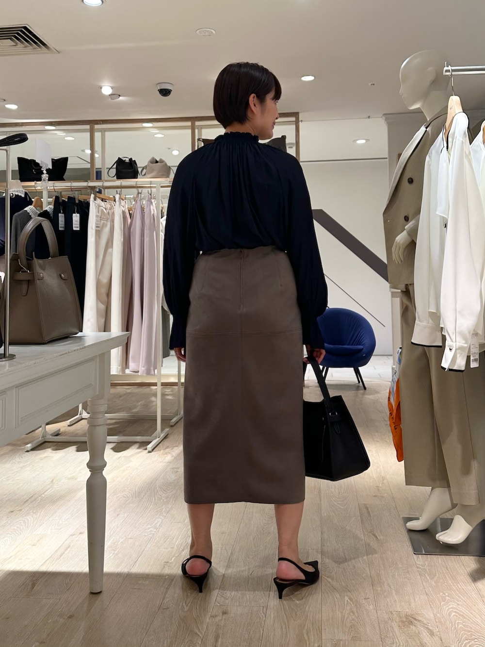 ブルー系のシャツ/ブラウス、グリーン系のスカート、ブラック系のショルダーバッグを着用したレディースの秋コーディネートの3枚目の写真