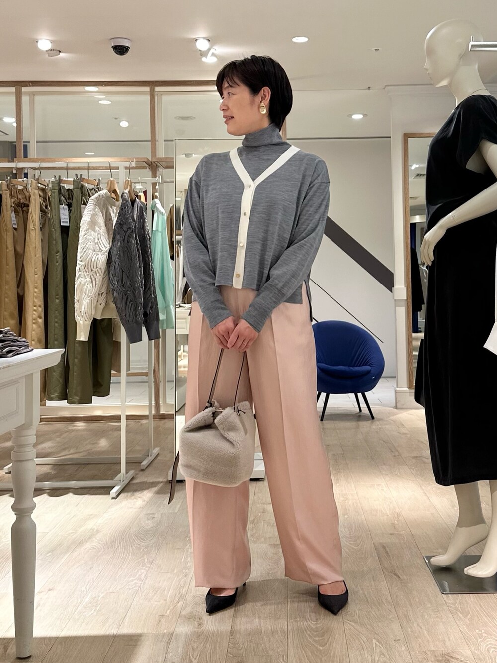 ベージュ系のショルダーバッグ、ピンク系のその他パンツ、グレー系のカーディガン/ボレロを着用したレディースの秋コーディネートの2枚目の写真