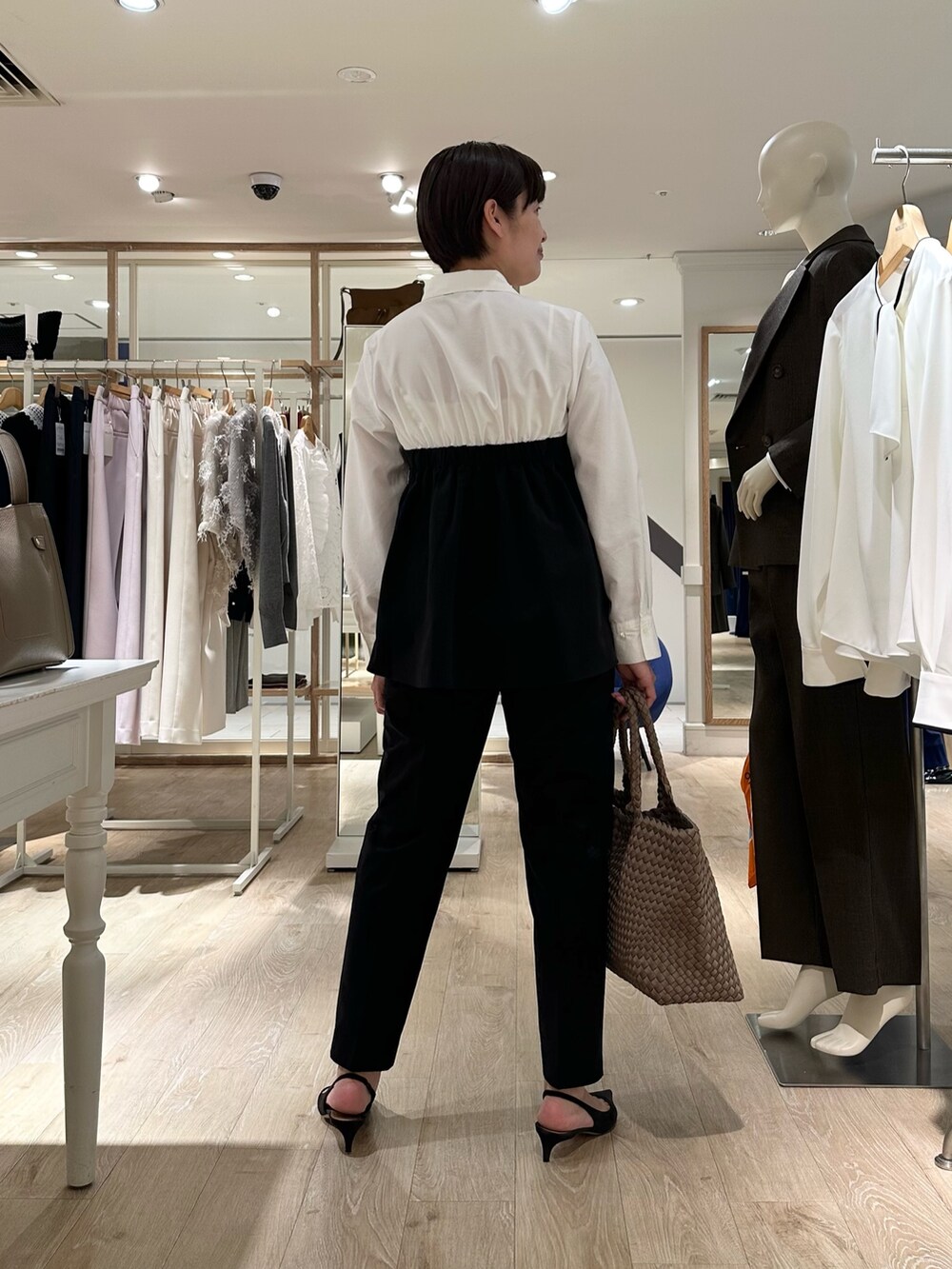 ブラック系のその他パンツ、ベージュ系のトートバッグ、ホワイト系のシャツ/ブラウスを着用したレディースの秋コーディネートの6枚目の写真