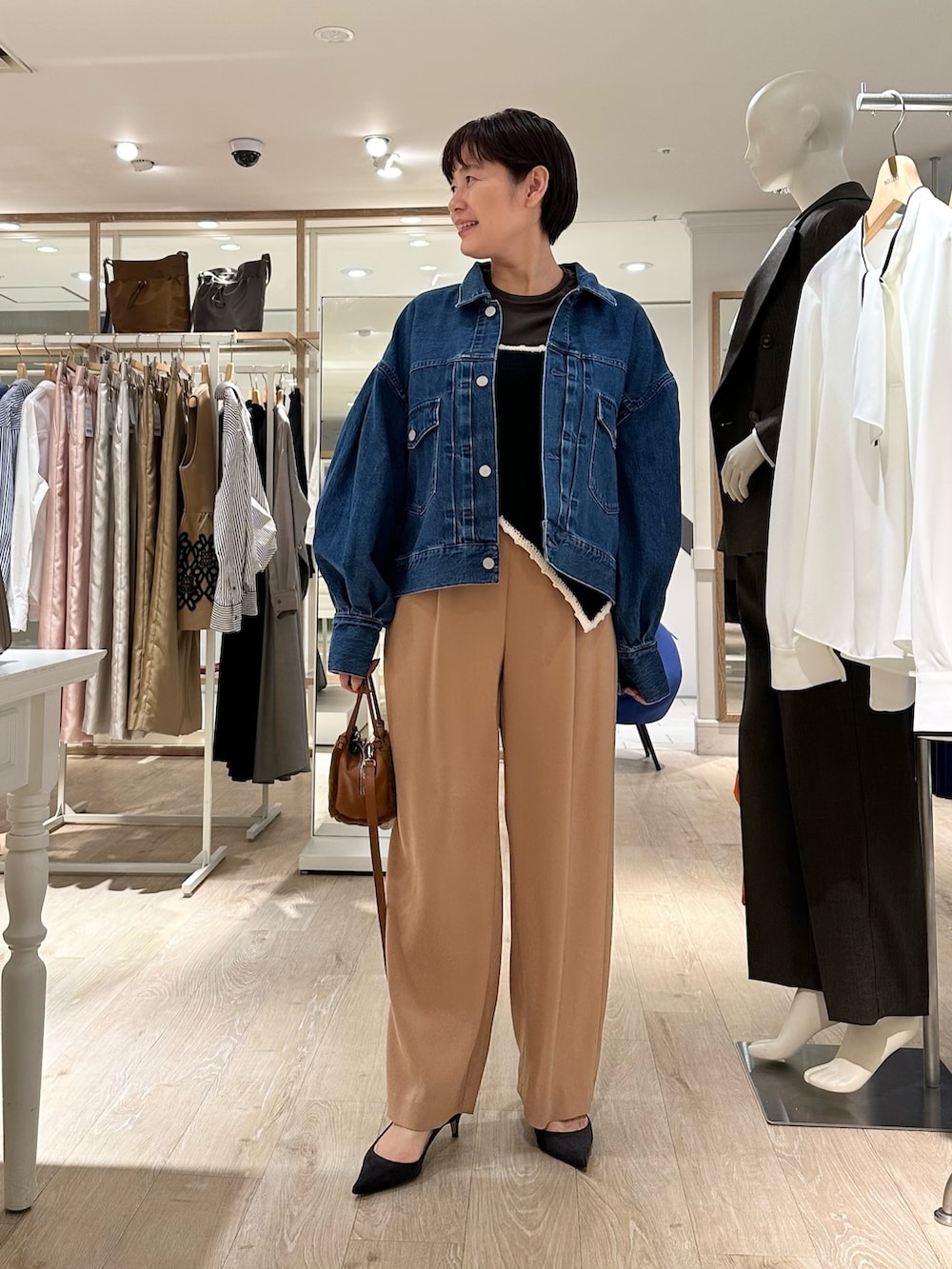 ブラック系のニット/セーター、イエロー系のショルダーバッグ、イエロー系のその他パンツを着用したレディースの秋コーディネートの4枚目の写真