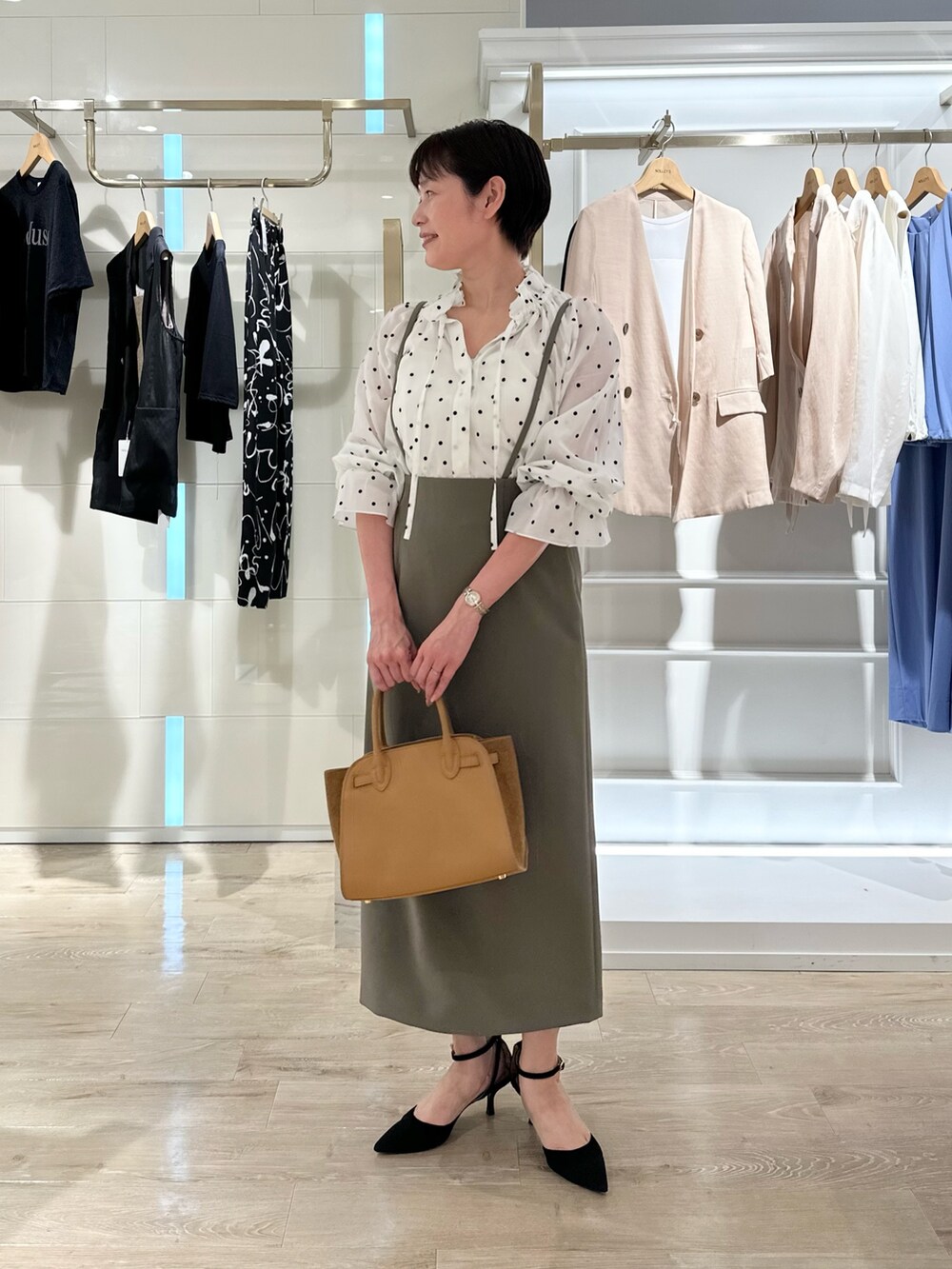 グリーン系のスカート、イエロー系のトートバッグ、ホワイト系のシャツ/ブラウスを着用したレディースの夏コーディネートの3枚目の写真