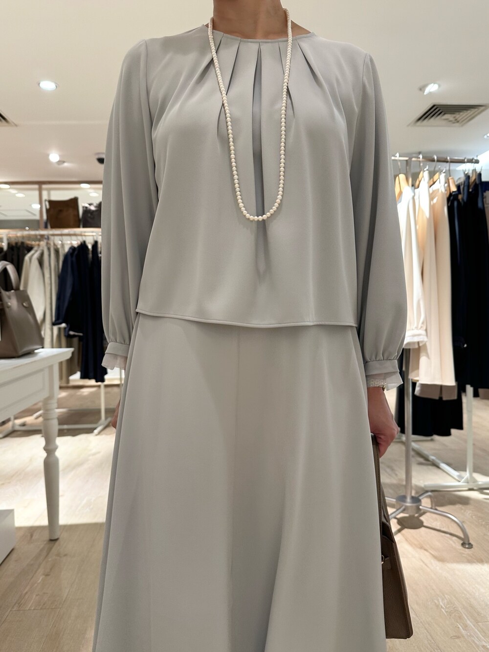 ベージュ系のショルダーバッグ、ブルー系のスカート、ブルー系のシャツ/ブラウスを着用したレディースの秋コーディネートの9枚目の写真