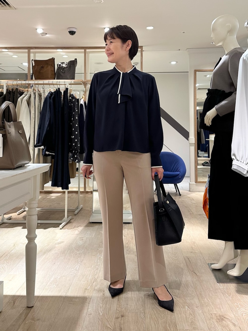 ベージュ系のその他パンツ、ブラック系のショルダーバッグ、ブルー系のシャツ/ブラウスを着用したレディースの秋コーディネートの2枚目の写真