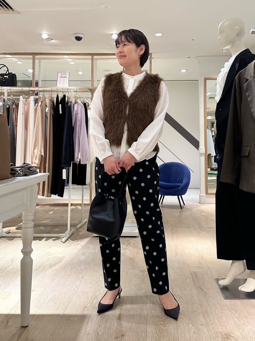 ブラック系のその他パンツ、ブラック系のショルダーバッグ、ホワイト系のシャツ/ブラウスを着用したレディースの秋コーディネートの7枚目の写真