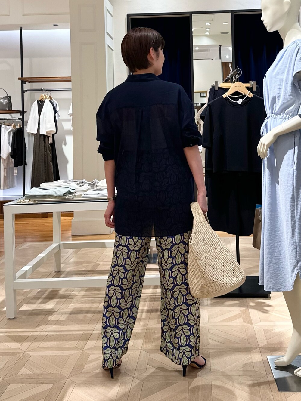 ブルー系のシャツ/ブラウス、グリーン系のその他パンツ、ベージュ系のかごバッグを着用したレディースの春コーディネートの3枚目の写真