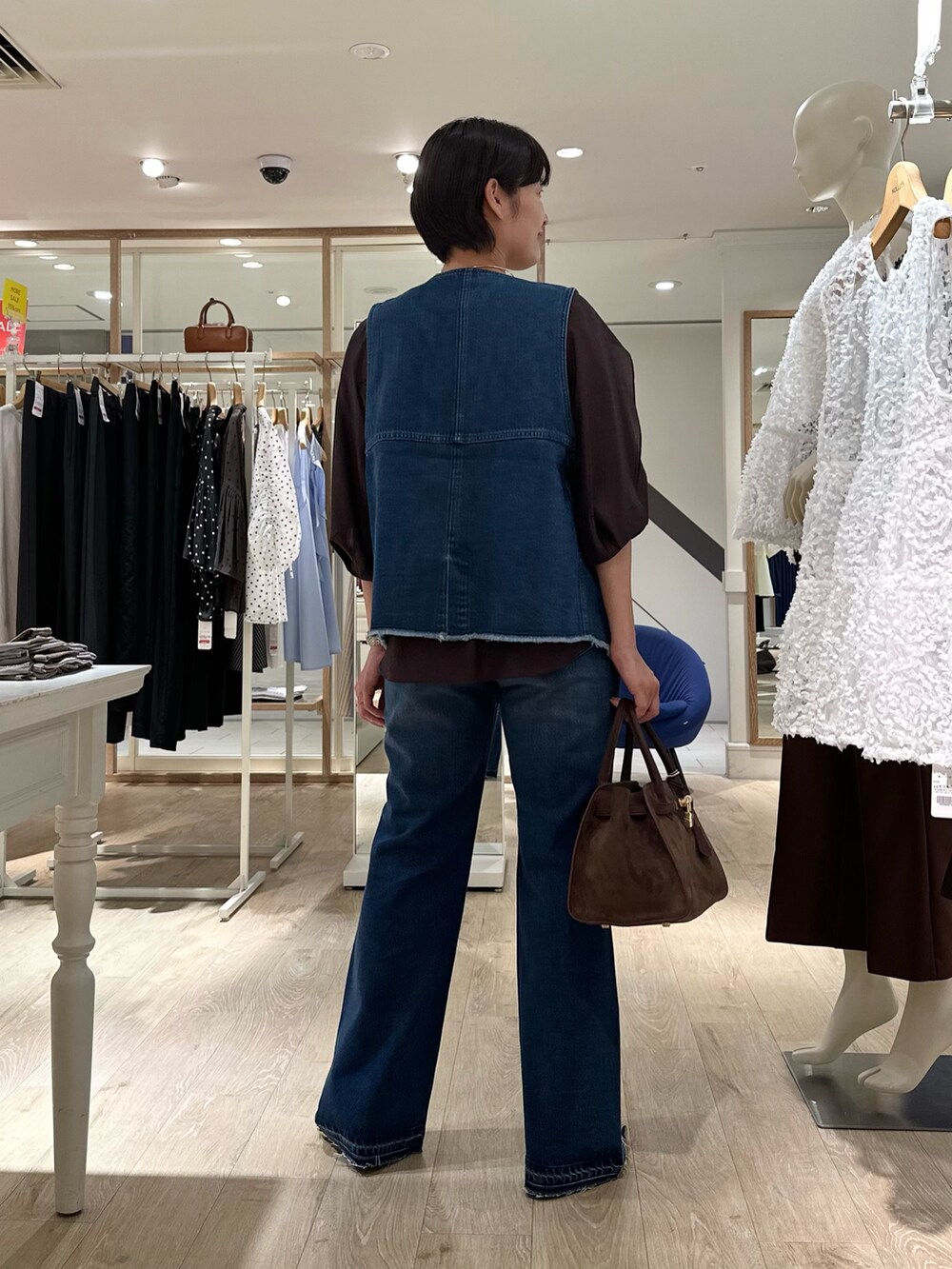 ブラウン系のシャツ/ブラウス、ブルー系のベスト、ブラウン系のトートバッグを着用したレディースの夏コーディネートの6枚目の写真