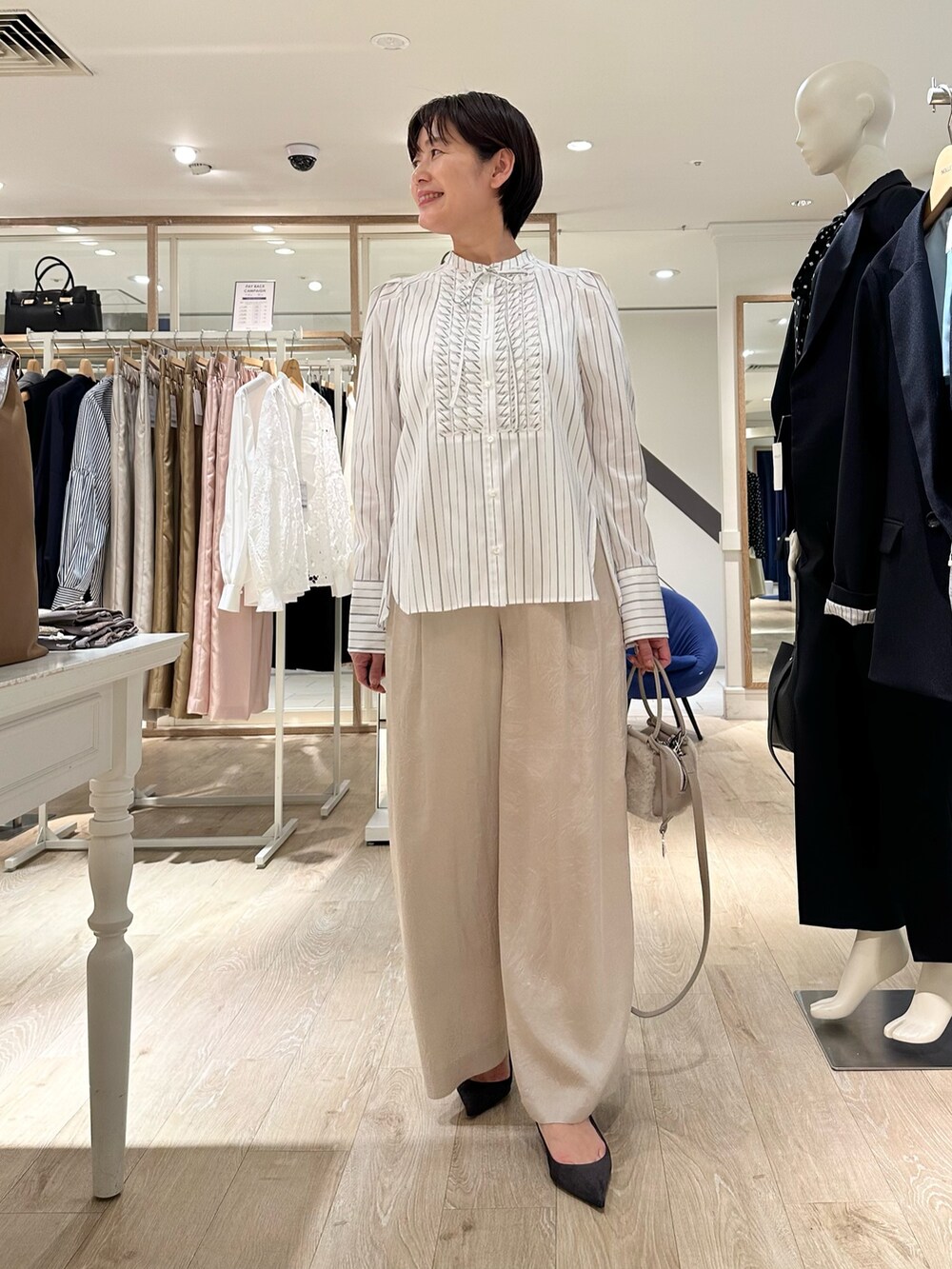 ホワイト系のシャツ/ブラウス、ベージュ系のショルダーバッグ、ベージュ系のその他パンツを着用したレディースの秋コーディネートの8枚目の写真